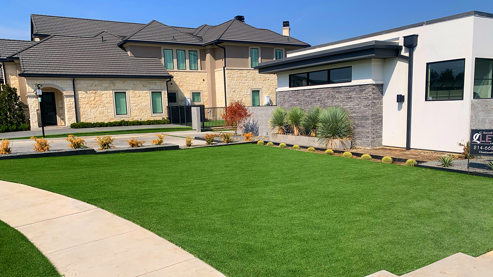 Sculpted artificial turf front yard with clean borders in front of a suburban home