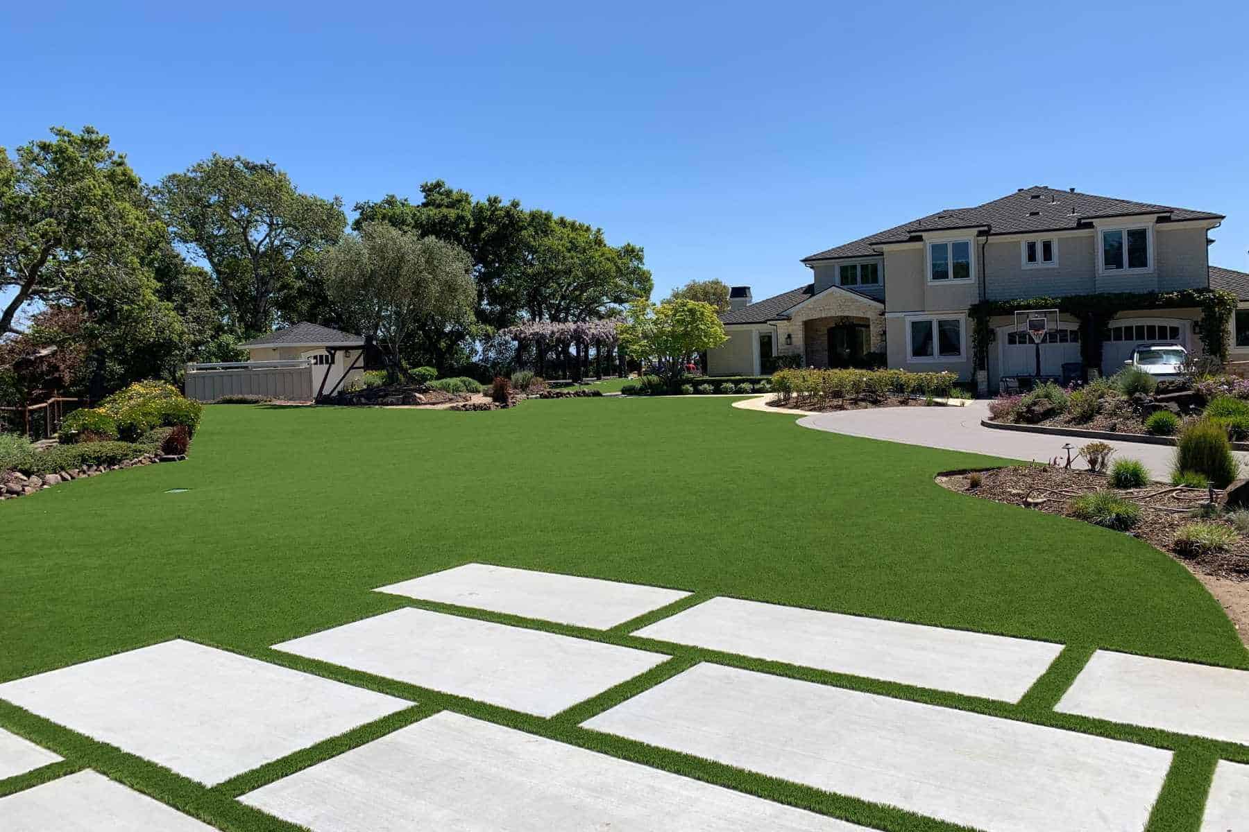 Expansive artificial turf front yard with large concrete pavers leading to a Sacramento-area home